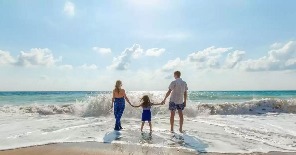 family-holding-hands-on-beach